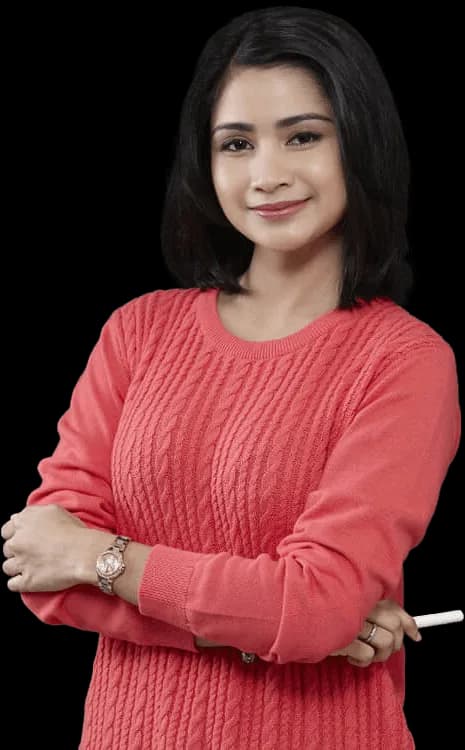 Smiling teacher standing in front of a classroom chalkboard